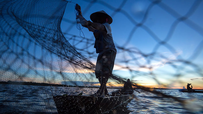 A fishermen casting his nest at sea