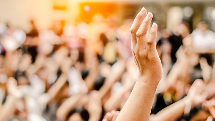 A group of people raising their hands on the street